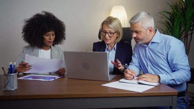 Caucasian businesswoman presenting ideas fr upcoming assignment talking in front of diverse colleagues. Diverse Team of Top Managers Talk, Discuss, Brainstorm, Use Laptop Computer. Business Partners 