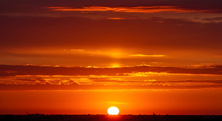 Fototapeta premium Captivating crimson dawn: A sun-kissed canvas of vivid red and golden hues