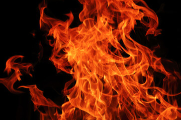 Fototapeta premium Vibrant orange flames against black background: dynamic fire patterns