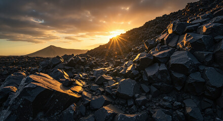 Dramatic rock formation illuminated by sunset under moody skies  