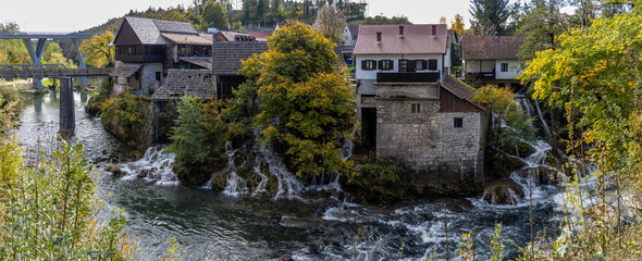 Panoramic photograph of the Rastoke Waterfalls, where the Slunjčica River meets the Korana River, creating a dreamlike landscape. Rastoke, Croatia