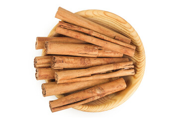 Cinnamon sticks in wooden bowl isolated on white background with full depth of field. Top view. Flat lay.