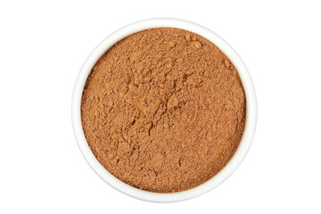 Cinnamon powder in ceramic bowl isolated on white background. Top view. Flat lay