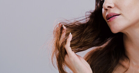Hand, split ends and woman with hair care, crisis and growth inspection on gray studio background. Person, closeup and model with shampoo problem, messy and damaged with mockup space and bad results