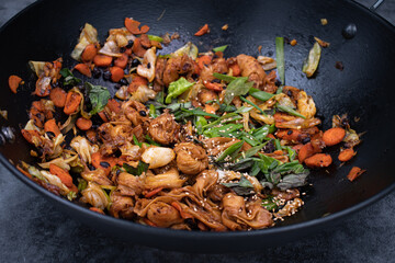 Yuba knots and veggie stir fry in cast iron wok, plant based Asian healthy food