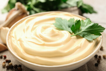 Delicious mayonnaise sauce with parsley in bowl on table, closeup