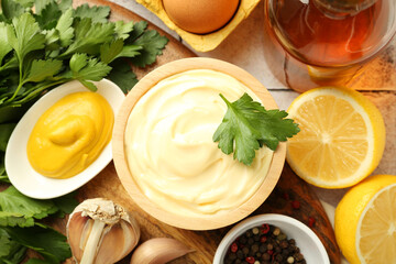 Delicious mayonnaise sauce with parsley, spices and products on table, flat lay
