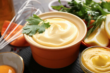 Delicious mayonnaise sauce in bowl and ingredients on grey table, closeup