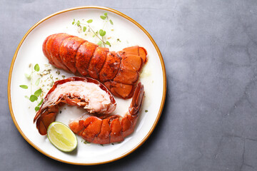 Delicious tails of boiled lobsters served on grey table, top view. Space for text
