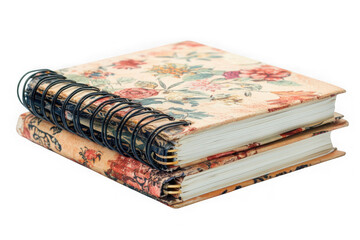 Two vintage spiral notebooks, adorned with delicate floral patterns, whisper tales of cherished memories and creative expression, their aged pages ready to capture new stories.