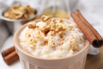 Tasty rice pudding with cinnamon on table, closeup