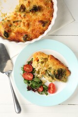 Tasty vegetable casserole and salad on white wooden table, flat lay