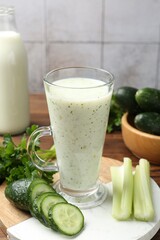Healthy parsley drink, leaves, celery and cucumber on wooden table, closeup