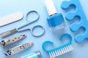 Set of different manicure tools on light blue background, flat lay