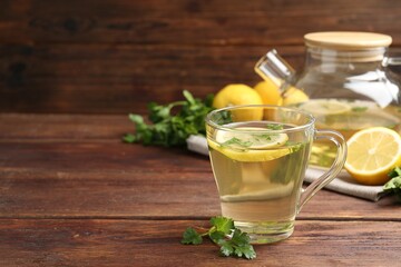 Healthy parsley tea with lemon slices on wooden table, space for text. Detox drink