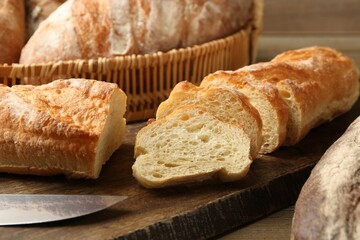 Different types of fresh bread on wooden table, closeup