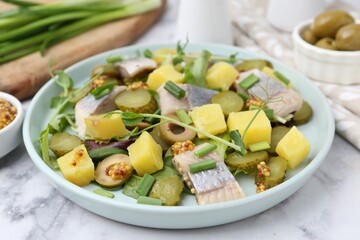 Delicious salad with herring and ingredients on white marble table, closeup