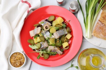 Delicious salad with herring and ingredients on white tiled table, flat lay