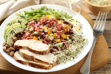 Tasty salad with brown rice served on wooden table, closeup