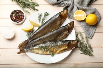 Smoked herrings and spices on wooden table, flat lay