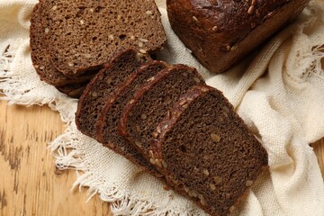 Pieces of fresh bread on wooden table, flat lay