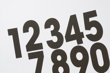 black paper machine-cut numbers (six missing) on white