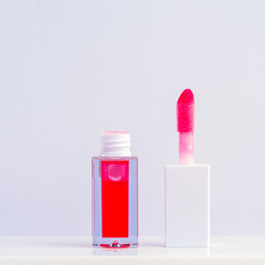 Bright Red Lip Gloss Opened on a White Minimalistic Background