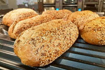 Freshly baked bread in wicker baskets. Rustic bread display in bakery. Handmade loaves with crusty...