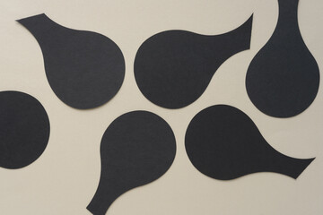 set of black paper shapes somewhat like bulbs on blank beige paper