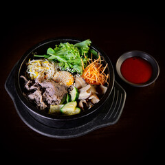 Classic Korean bibimbap served in a hot stone bowl with mixed vegetables, bulgogi beef, fried egg, and gochujang, a signature dish of Korean cuisine