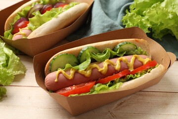 Tasty hot dogs on wooden table, closeup