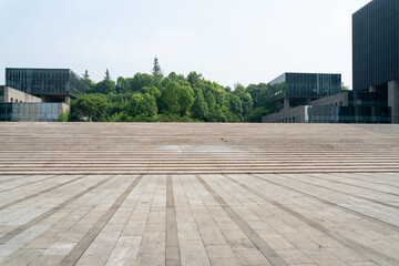 Obraz premium empty concrete ground in front of modern office buildings in downtown. floor for copy space