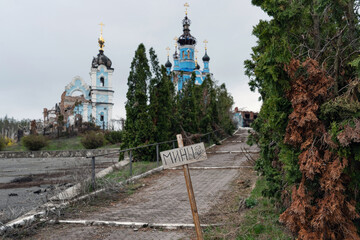 The inscription "mines". During the retreat, the territory was mined by Russian troops. In the background are the ruins of church and a monastery.