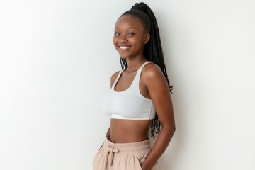 Fototapeta premium Half-Length (Waist-Up) portrait of young stylish smiling Tanzanian female model in sporty wear isolated on pure white background looking at camera