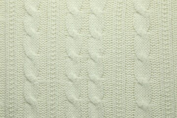 Knitted white woolen fabric as background, top view