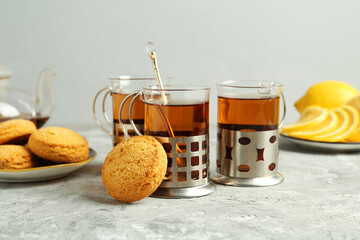 Glasses of tea in metal holders served on grey textured table