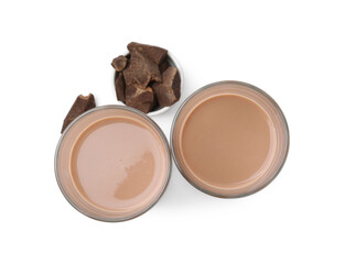 Tasty chocolate milk in glasses and pieces of chocolate isolated on white, top view