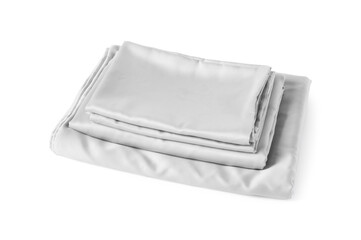 Stack of silky bed linens on white background