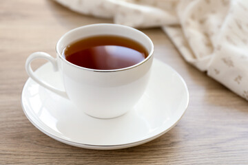 Aromatic tea in cup on wooden table, closeup