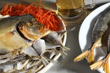 Different dried fish and beer on grey textured table, closeup