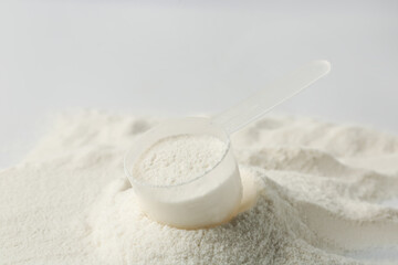 Collagen powder and scoop on light background, closeup