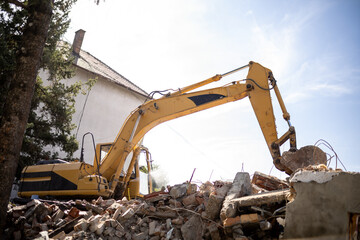 Heavy machinery removes debris from a building site in urban area during the day