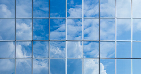 Sky and clouds reflection on the glass facade of modern building, glass facade of a skyscraper...
