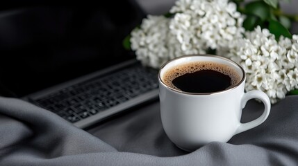 Obraz premium A cup of coffee, laptop, and flowers