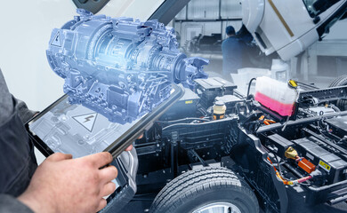 Serviceman with digital tablet repair electric truck using augmented reality.. Electric vehicles...