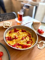 Turkish scrambled egg with red pepper or bell pepper in copper with turkish tea