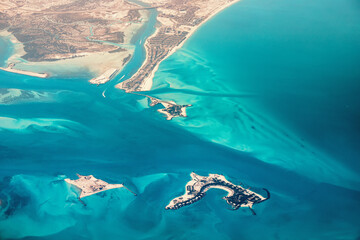 Aerial view of artificial islands under construction near the coast, showing luxury resorts and...