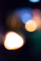 Abstract blurred bokeh lights in warm and cool tones, defocused night city background with soft glow. 