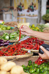 a hand selecting red chillies