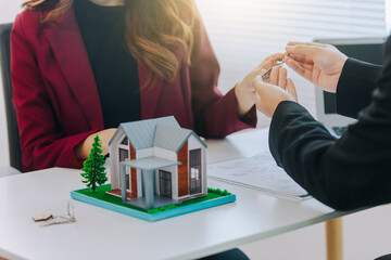 Businessman, house and condo sales representative Hand over the keys to the customer and sign the...